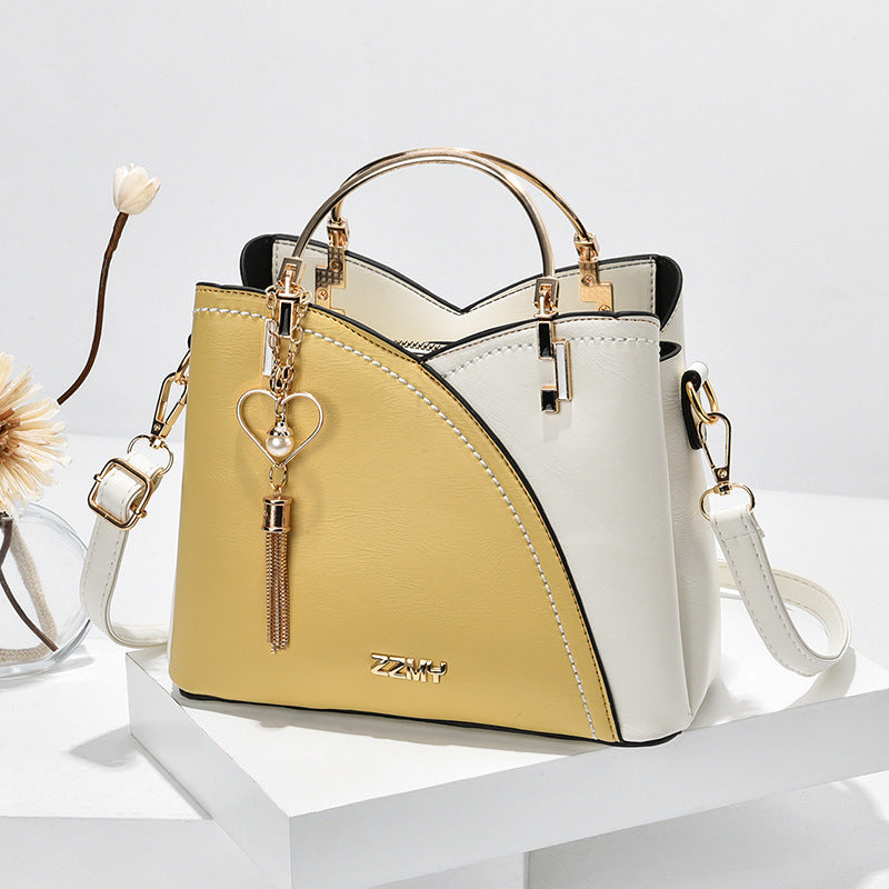 Chic Contrast: Signature Two-Tone Shoulder Bag with Heart Charm Accent Feminé Luxé