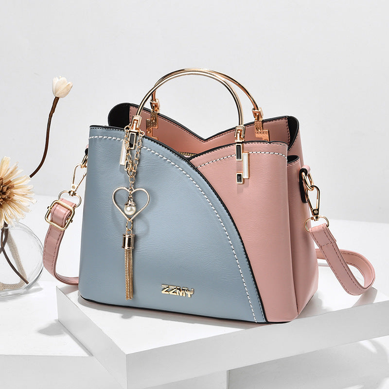 Chic Contrast: Signature Two-Tone Shoulder Bag with Heart Charm Accent Feminé Luxé