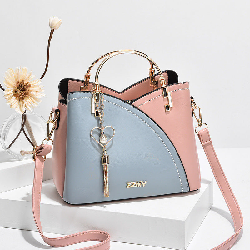 Chic Contrast: Signature Two-Tone Shoulder Bag with Heart Charm Accent Feminé Luxé
