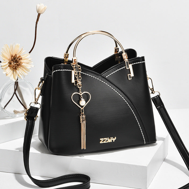 Chic Contrast: Signature Two-Tone Shoulder Bag with Heart Charm Accent Feminé Luxé