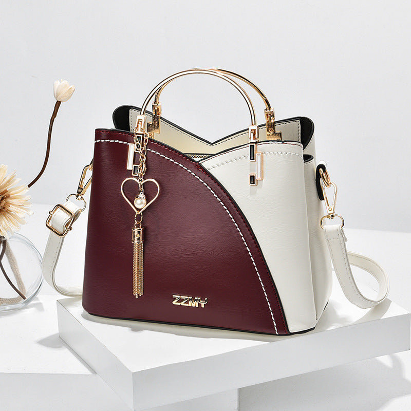 Chic Contrast: Signature Two-Tone Shoulder Bag with Heart Charm Accent Feminé Luxé