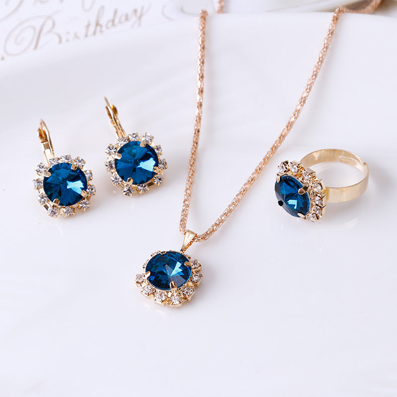 Chic Euro-American Round Crystal Jewelry Set: Sapphire/Ruby Solitaire Necklace, Drop Earrings & Ring Trio Feminé Luxé
