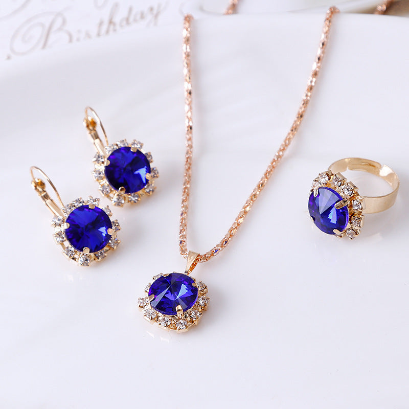 Chic Euro-American Round Crystal Jewelry Set: Sapphire/Ruby Solitaire Necklace, Drop Earrings & Ring Trio Feminé Luxé