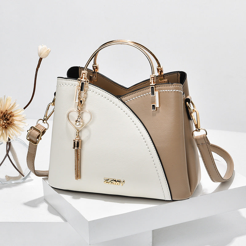 Chic Contrast: Signature Two-Tone Shoulder Bag with Heart Charm Accent Feminé Luxé