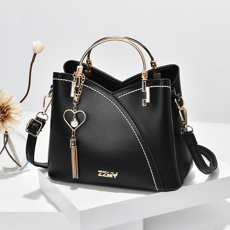Chic Contrast: Signature Two-Tone Shoulder Bag with Heart Charm Accent Feminé Luxé