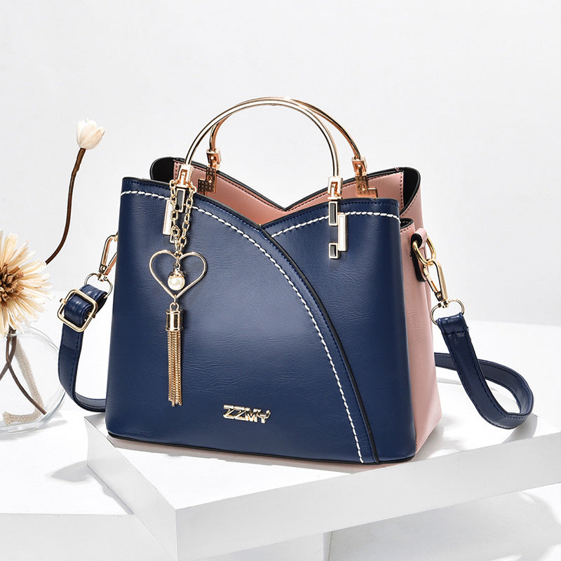 Chic Contrast: Signature Two-Tone Shoulder Bag with Heart Charm Accent Feminé Luxé